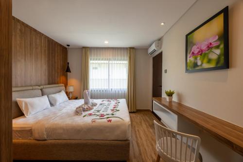 a bedroom with a bed with a stuffed animal on it at Kana Suites Nusa Dua By Fays Hospitality in Nusa Dua