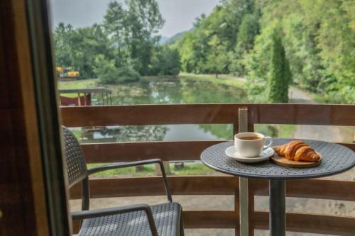 a table with a cup of coffee and croissants on a balcony at Ribnik Stari trg in Lesično