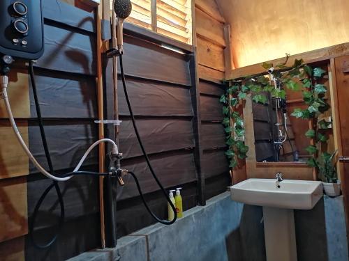 a bathroom with a sink next to a mirror at The Cliff Lodge Ella in Ella