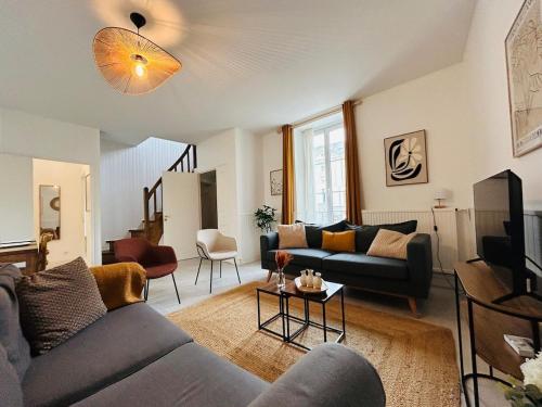 a living room with a couch and a tv at Casa Douce Angevine in Angers