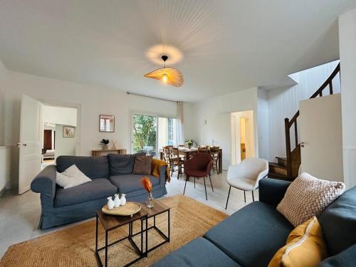 a living room with blue couches and a dining room at Casa Douce Angevine in Angers