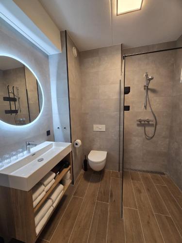 a bathroom with a shower and a sink and a toilet at Hotel De Bonte Wever Assen in Assen