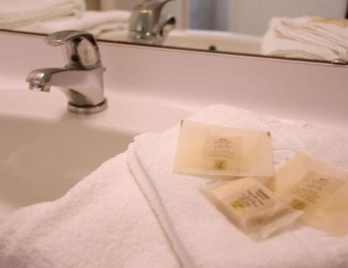 a bathroom sink with towels and a faucet at Le Parasol in Ars-en-Ré