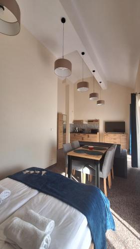 a bedroom with a bed and a table in a room at Skalnica- apartamenty z widokiem na góry, przy szlakach in Karpacz