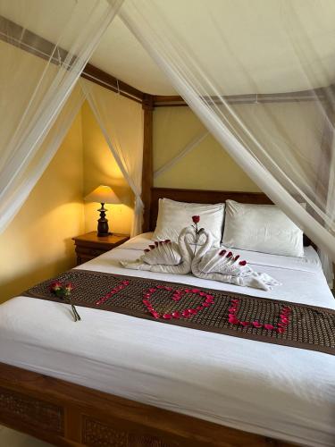 a bedroom with a bed with a canopy at Ariartha homestay in Ubud