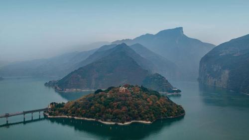 an island in the middle of a lake with a bridge at PORTAL ART HOTEL in Fengjie