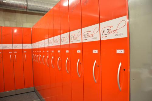 a row of orange lockers in a room at Aparthotel AlpTirol in Kaltenbach