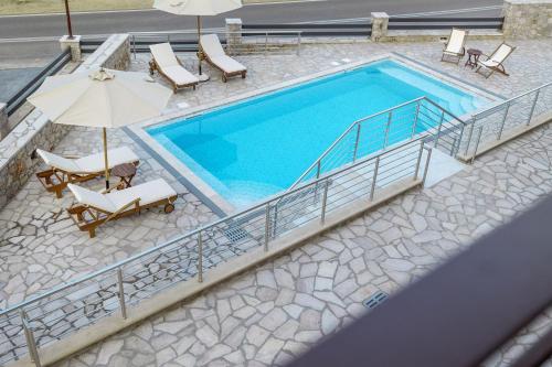 an overhead view of a swimming pool with chairs and an umbrella at Elevi Aria in Tyros