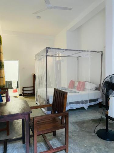 a bedroom with a bed with a canopy at Hiriketiya Hasmal House in Hiriketiya