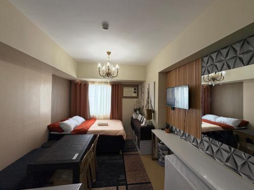 a small room with two beds and a chandelier at Avida Aspira Tower 1 - Chads Unit 8th Floor in Cagayan de Oro