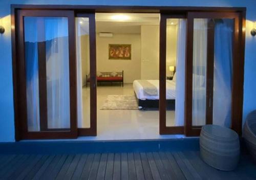 a view of a bedroom with a bed through a sliding glass door at Nadira BnB in Munduk
