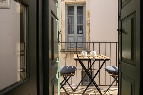 a balcony with a table and two mugs on it at Old Town Stone Residence in Rethymno
