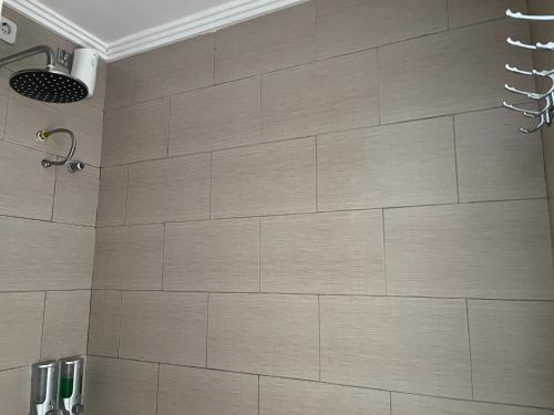 a bathroom with a tiled wall and a shower at Ariartha homestay in Ubud