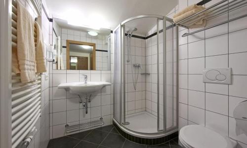 a bathroom with a shower and a sink at Hotel Pinzgauerhof by Alpeffect Hotels in Zell am See