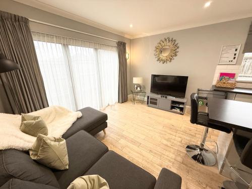 a living room with a couch and a flat screen tv at Northwood 2 in Broadstairs