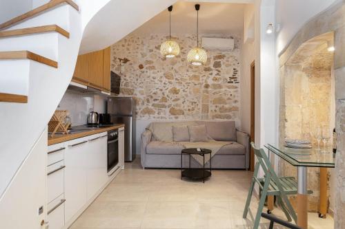 a kitchen and living room with a couch and a table at Old Town Stone Residence in Rethymno