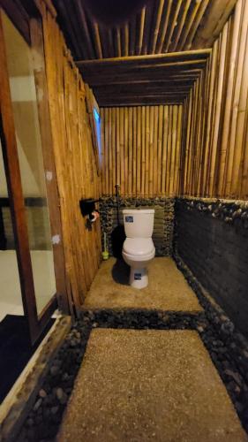 a bathroom with a toilet in a wooden structure at Zalfa Homestay in Taliwang