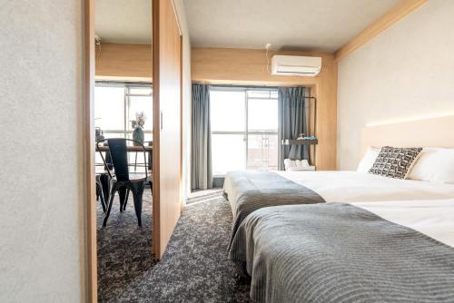 a hotel room with two beds and a table at b&新大阪店 in Osaka