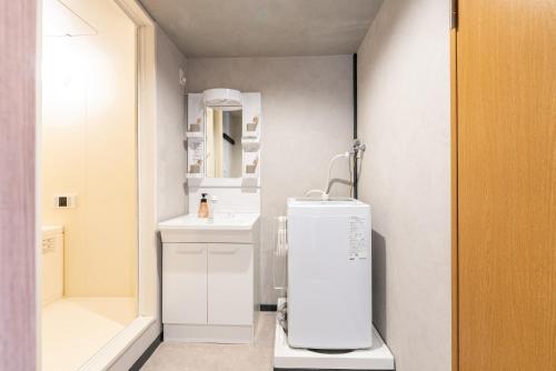 a small white bathroom with a sink and a mirror at b&新大阪店 in Osaka