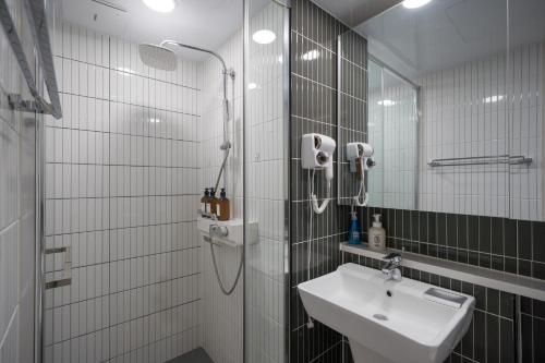 a white bathroom with a sink and a shower at Daegu lily Residence Hotel in Daegu