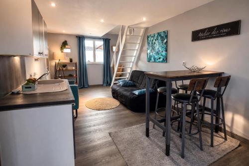 a kitchen and living room with a table and a couch at Le petit nid de St-Germain in Saint-Germain