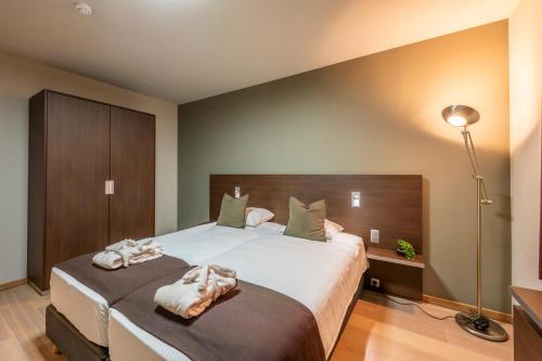 a bedroom with a large bed with towels on it at Hotel Falko in Meise
