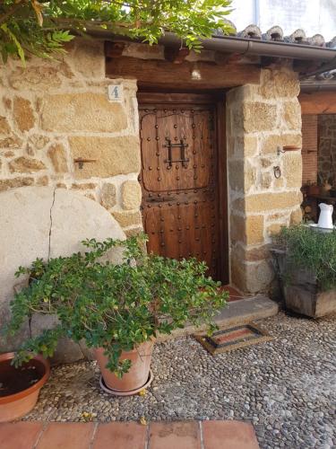 an entrance to a stone building with a wooden door at El Atalanto in Madrigal de la Vera