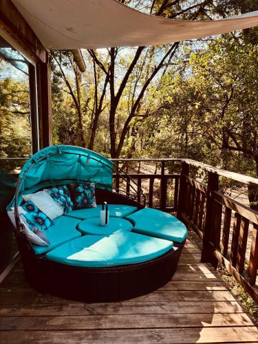 a blue bed on a wooden deck with a tent at Le chalet du Rêveur in La Gaude