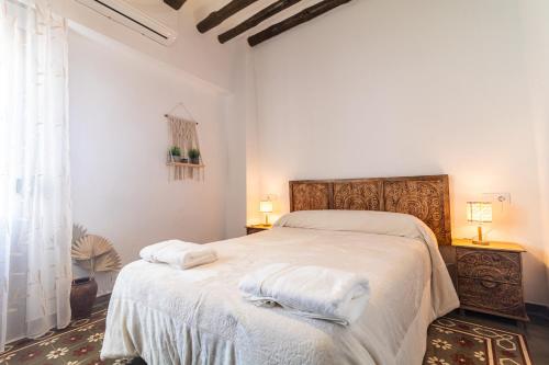 a bedroom with a large bed with towels on it at El Carmen - Villa Rural con Piscina Privada y Patio Andaluz in Ugíjar