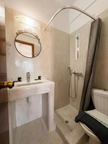 a bathroom with a sink and a shower with a mirror at Aegean Nest Beach Studios - Adults only in Monolithos
