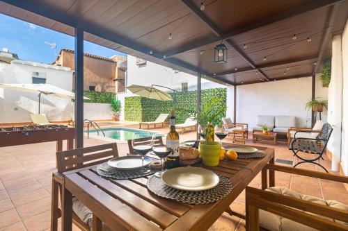 a wooden table with plates of food on a patio at El Carmen - Villa Rural con Piscina Privada y Patio Andaluz in Ugíjar