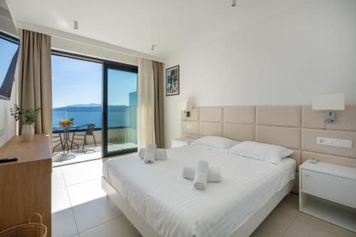 a bedroom with a bed with a view of the ocean at Wind Rose Maestral-beachfront in Igrane