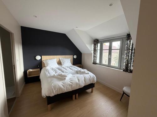 a bedroom with a large bed with a black wall at Le Refuge des Clavendiers in Nuits-Saint-Georges