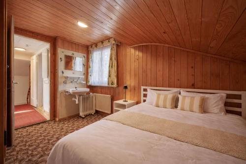 a bedroom with a large bed and a sink at Cozy traditional Chalet, Stunning Mountain Views in Grindelwald