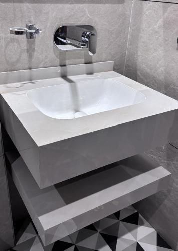a white sink with a faucet in a bathroom at Hotel Classic in Pānīpat