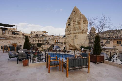 a patio with tables and chairs in front of a building at Göreme Cave Suites in Göreme