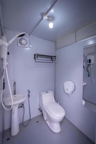 a white bathroom with a toilet and a sink at The Coco Journey - Eco Tent in Kelebang Besar