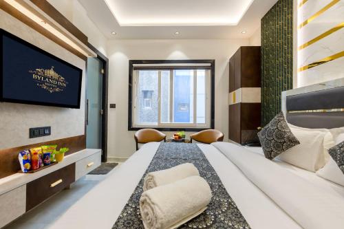 a bedroom with a large bed and a tv at Hotel Byland Inn- Near Connaught Place And 5 Minutes From New Delhi Station in New Delhi