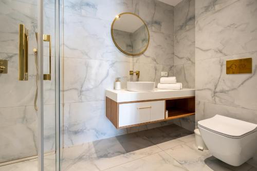 a bathroom with a toilet sink and a mirror at Wind Rose Maestral-beachfront in Igrane