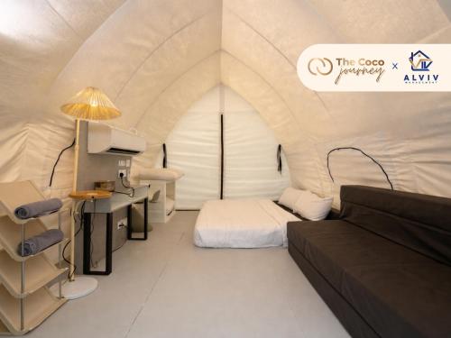 a room with a couch and a bed in a tent at The Coco Journey - Eco Tent in Kelebang Besar