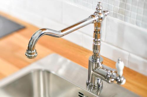 a kitchen sink with a chrome kitchen faucet at Bla Marine Domki nad Morzem in Grzybowo