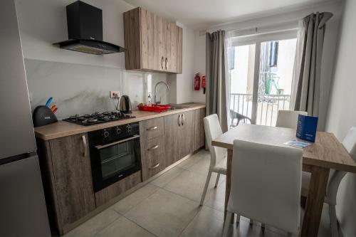a kitchen with a table and a stove top oven at Stillel SkyLounge Suites in St. Paul's Bay