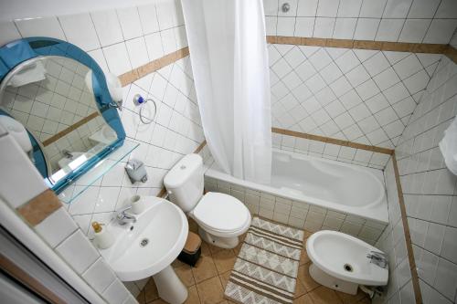 a bathroom with a sink and a toilet and a tub at Old Bazaar Balcony Villa in Gjirokastër