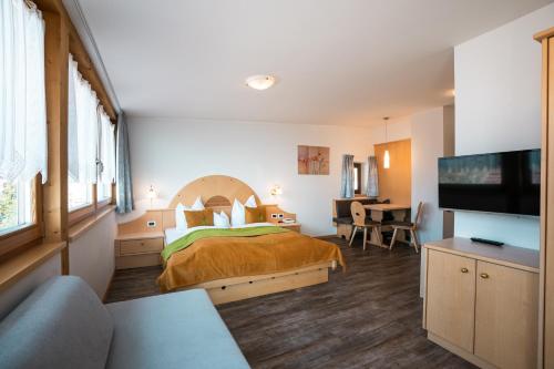 a hotel room with a bed and a television at Residence Innerfarmerhof in Tirolo