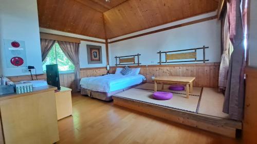 a bedroom with a bed and a table in a room at Yosemite Park B&B in Ren'ai