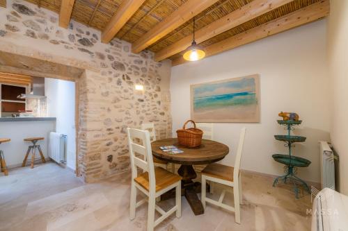a dining room with a wooden table and chairs at Casa Abeurador, con mucho encanto en el centro de Artà in Artá