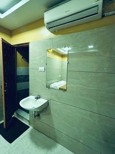 a bathroom with a sink and a mirror at GSR RESIDENCy in Kanchipuram