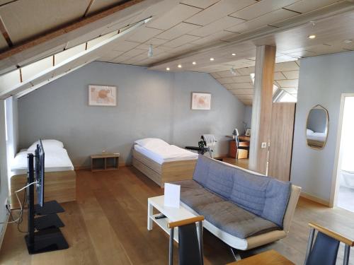 ein Wohnzimmer mit zwei Betten und einer Couch in der Unterkunft Apartment-Design 1, Altendtadt in Altenstadt