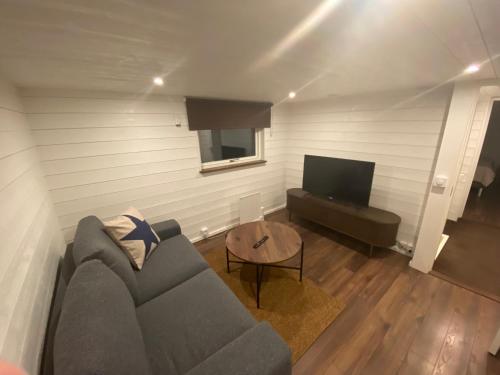 a living room with a couch and a television at Port Hotel Ocean Villa in Karlshamn