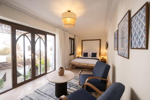 a hotel room with a bed and a table and chairs at Riad Le Saadien ,Adult only in Marrakesh